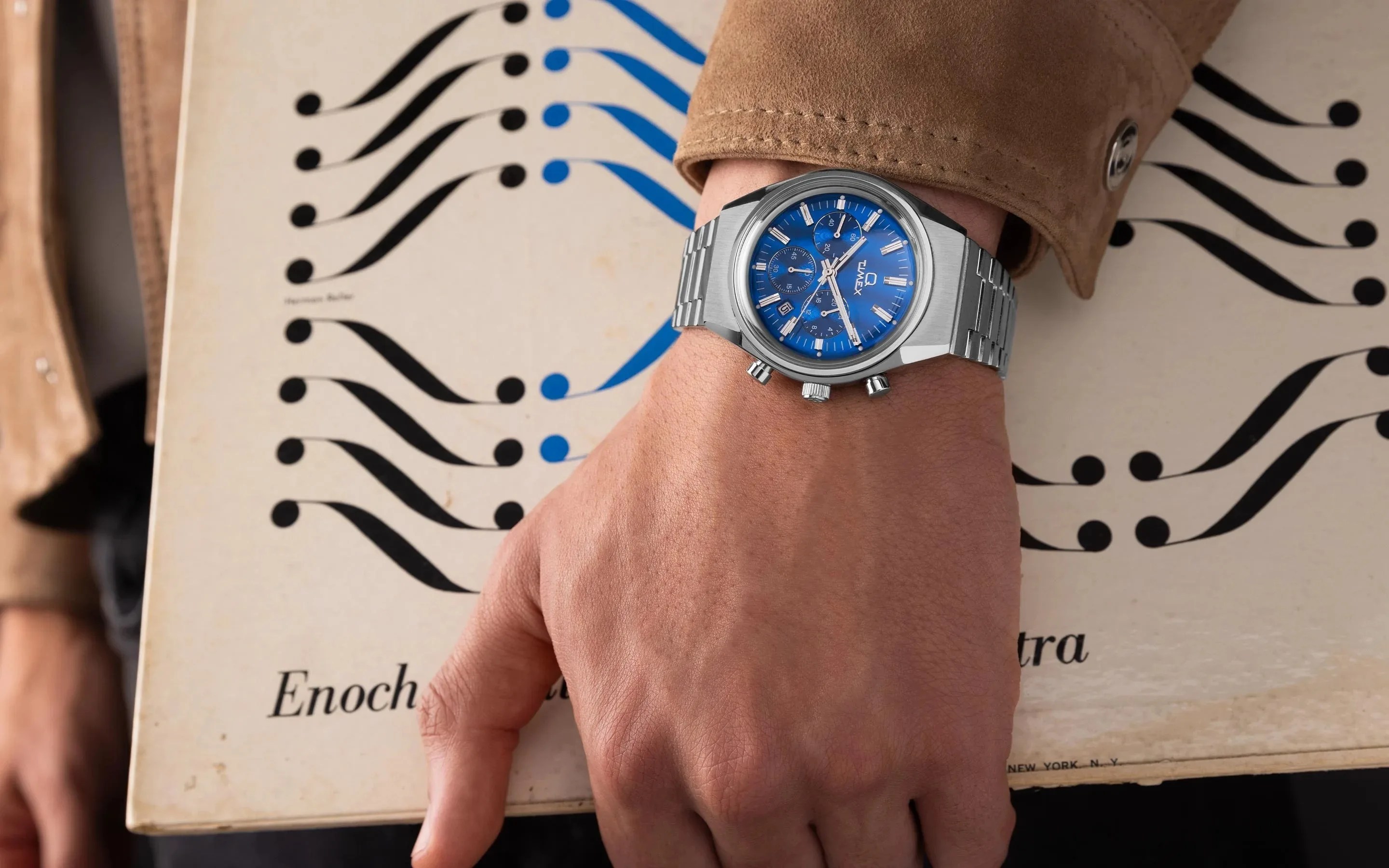 Blue timex watch on mans wrist as he carries a vinyl record