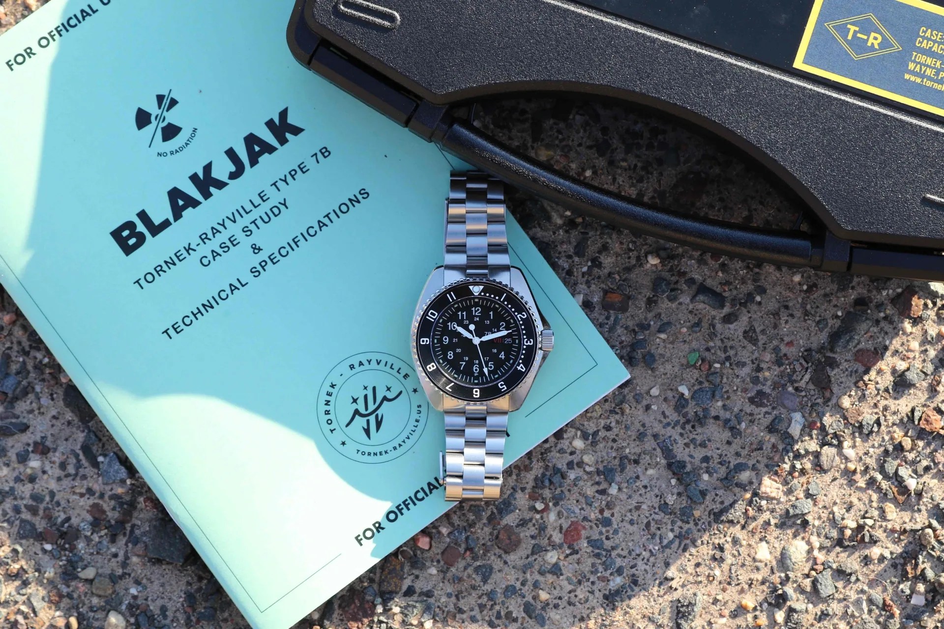 a tornek rayville military watch on a booklet by a plastic case