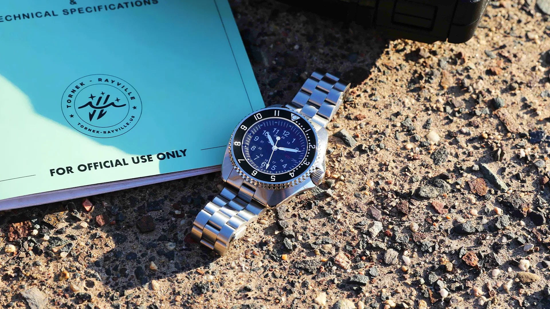 tornek rayville blakjak watch on a stone surface next to a handbook