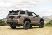 2025 Toyota 4Runner in Mudbath color shown from rear on dirt road.