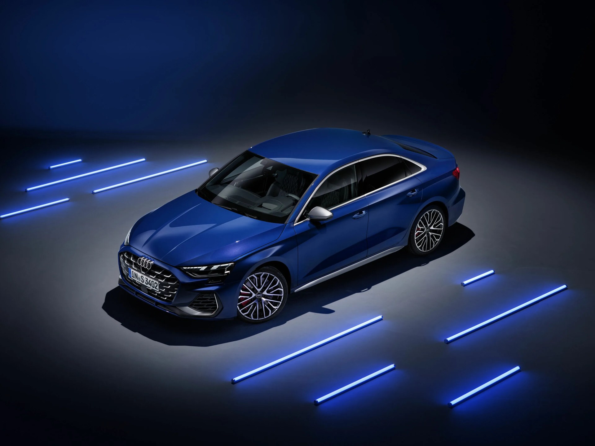Audi S3 2025 in blue next lined by blue neon lights