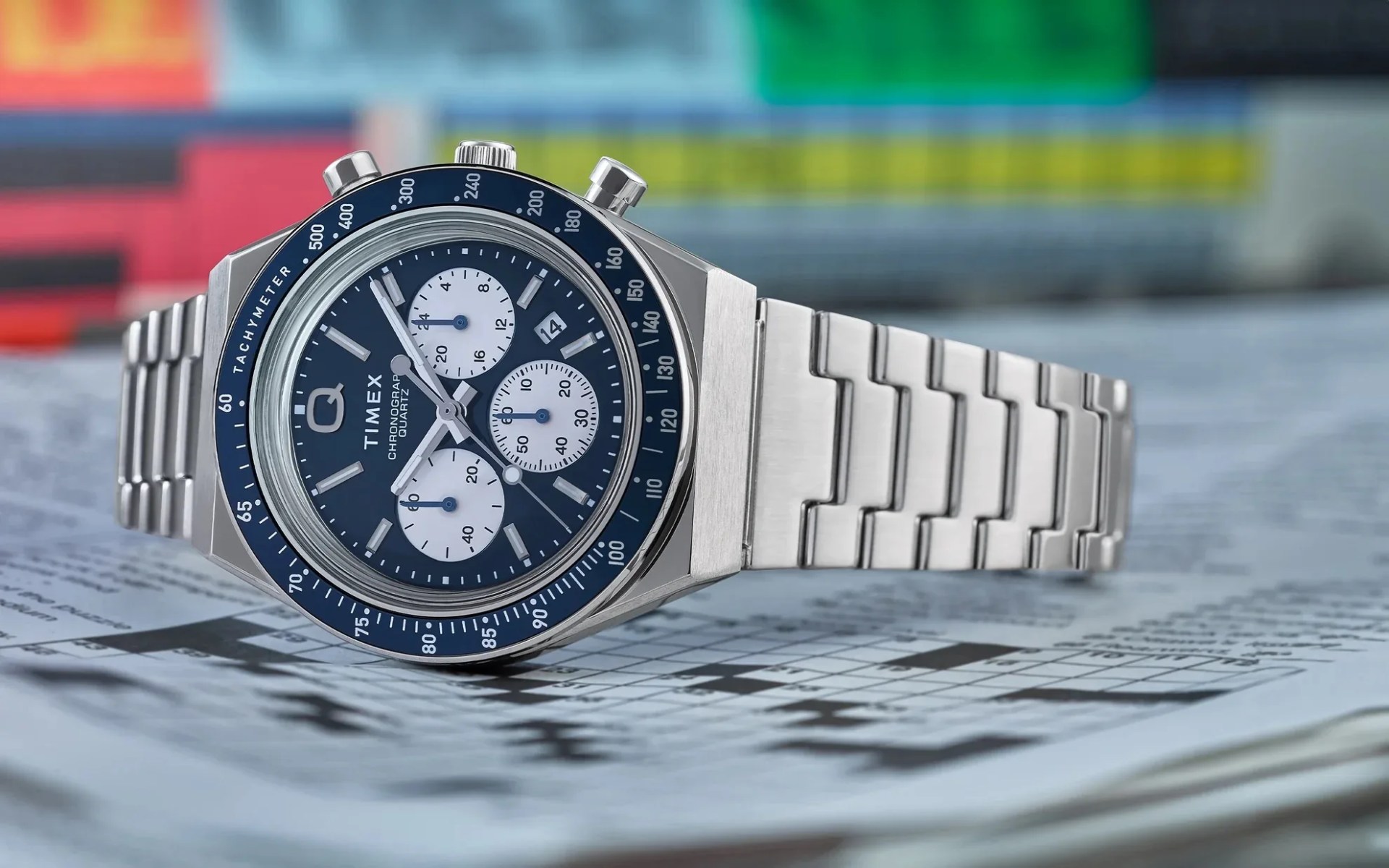 blue timex chronograph watch lying on a crossword puzzle