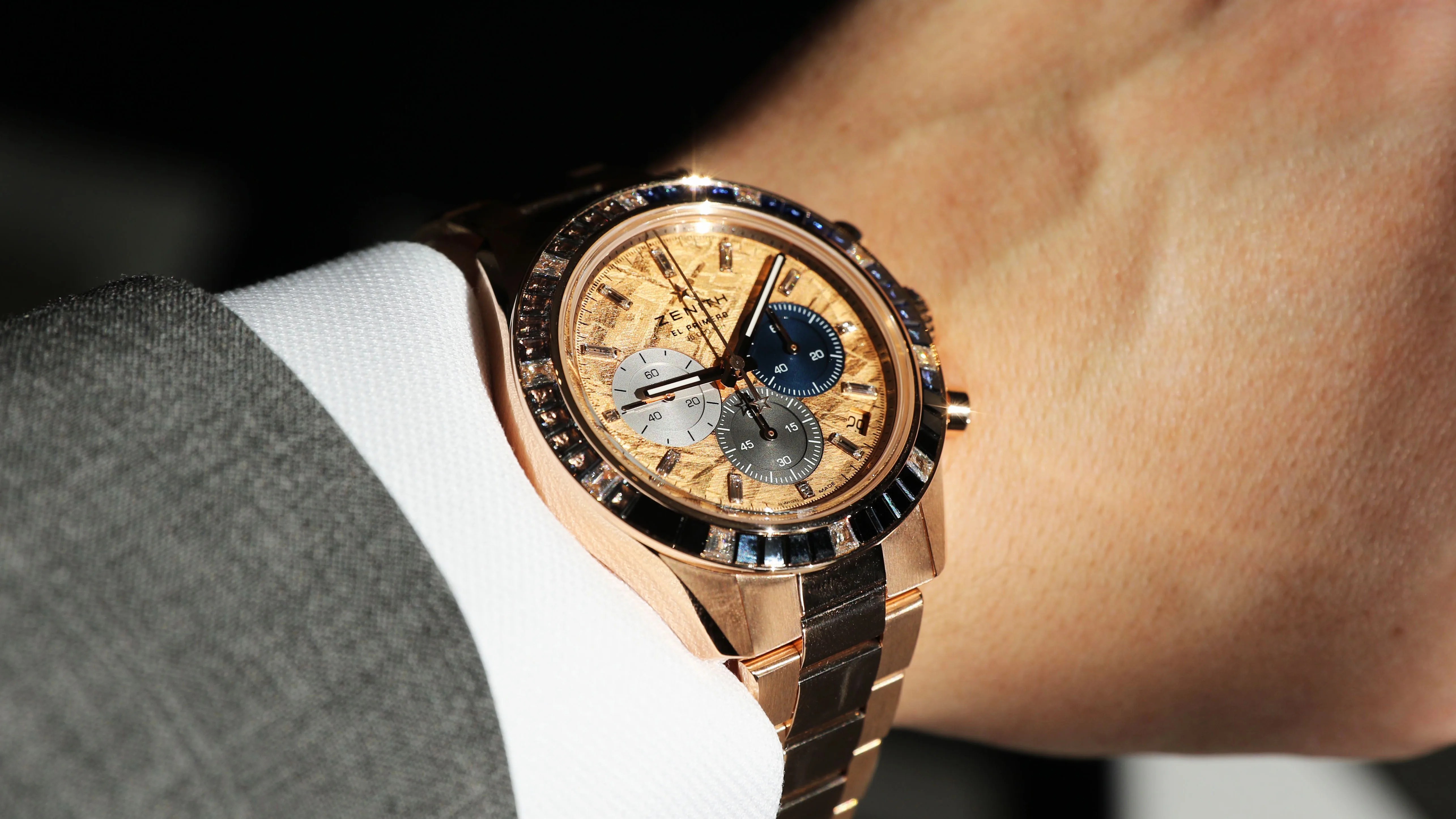 gold zenith watch on mans wrist