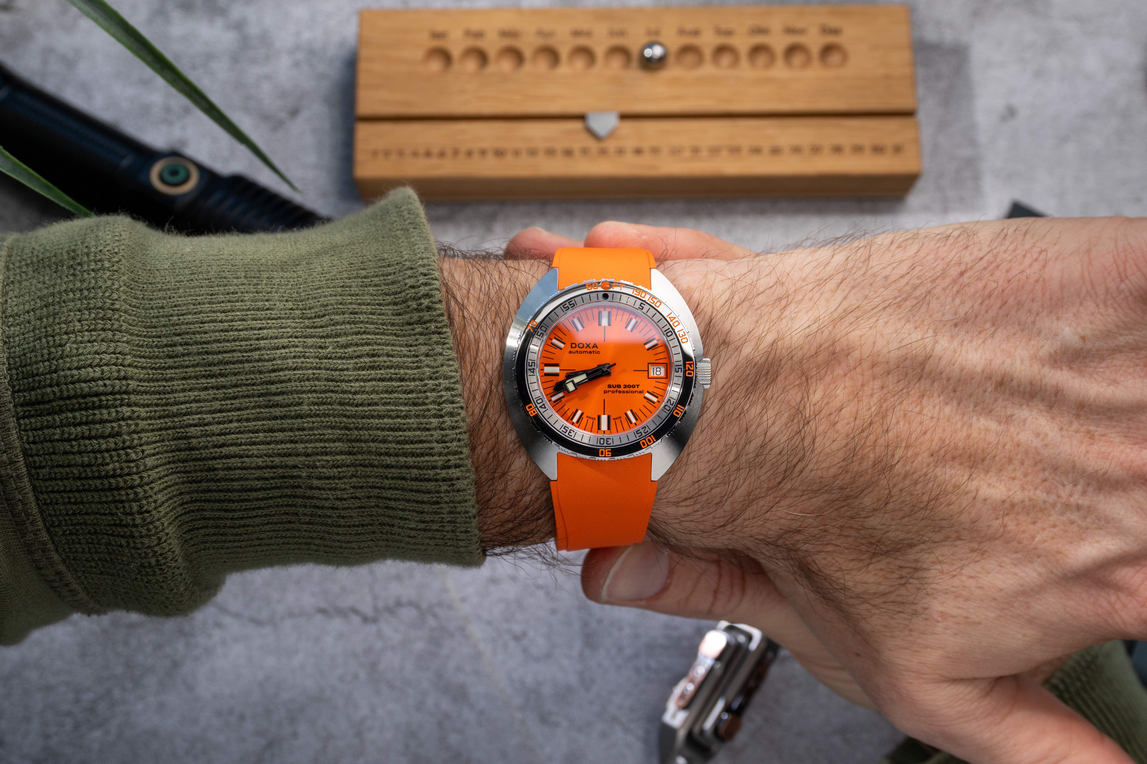 orange doxa dive watch on a mans wrist