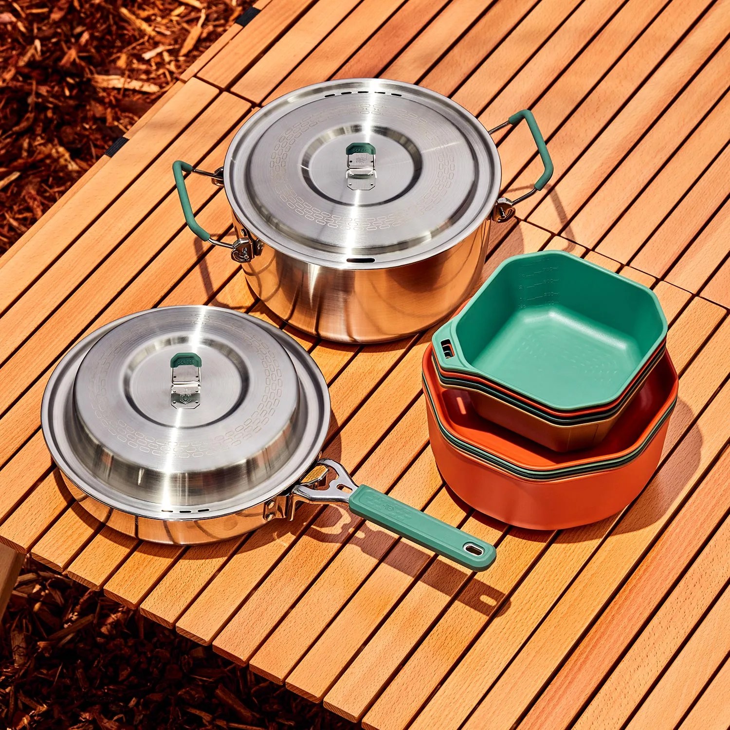 camp cooking pans and bowls on slated wood surface