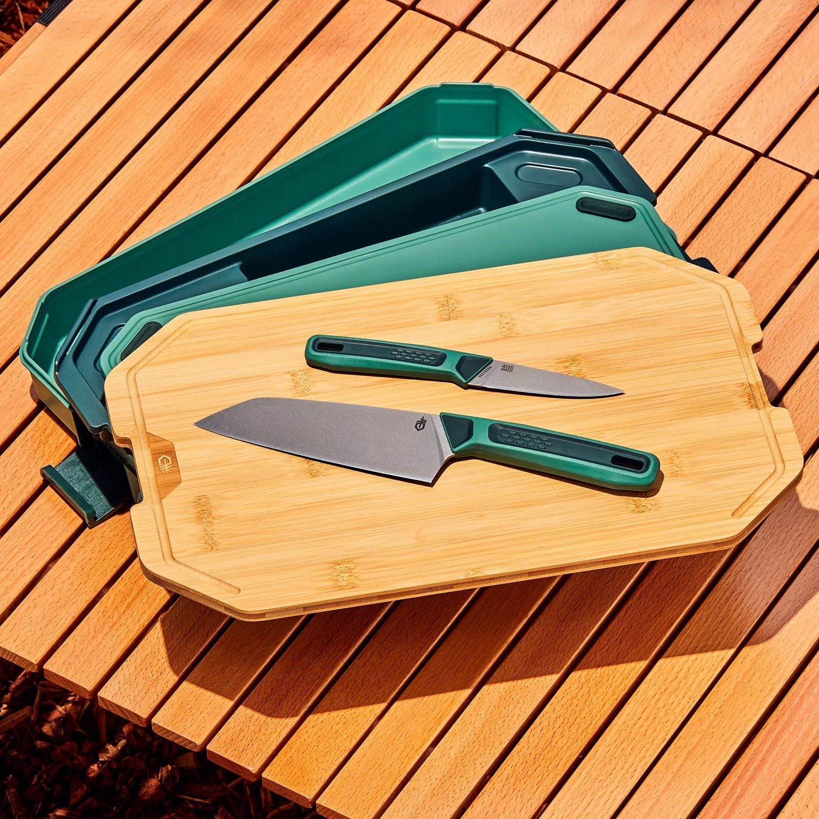 camping cutting board and knives on slated wood surface