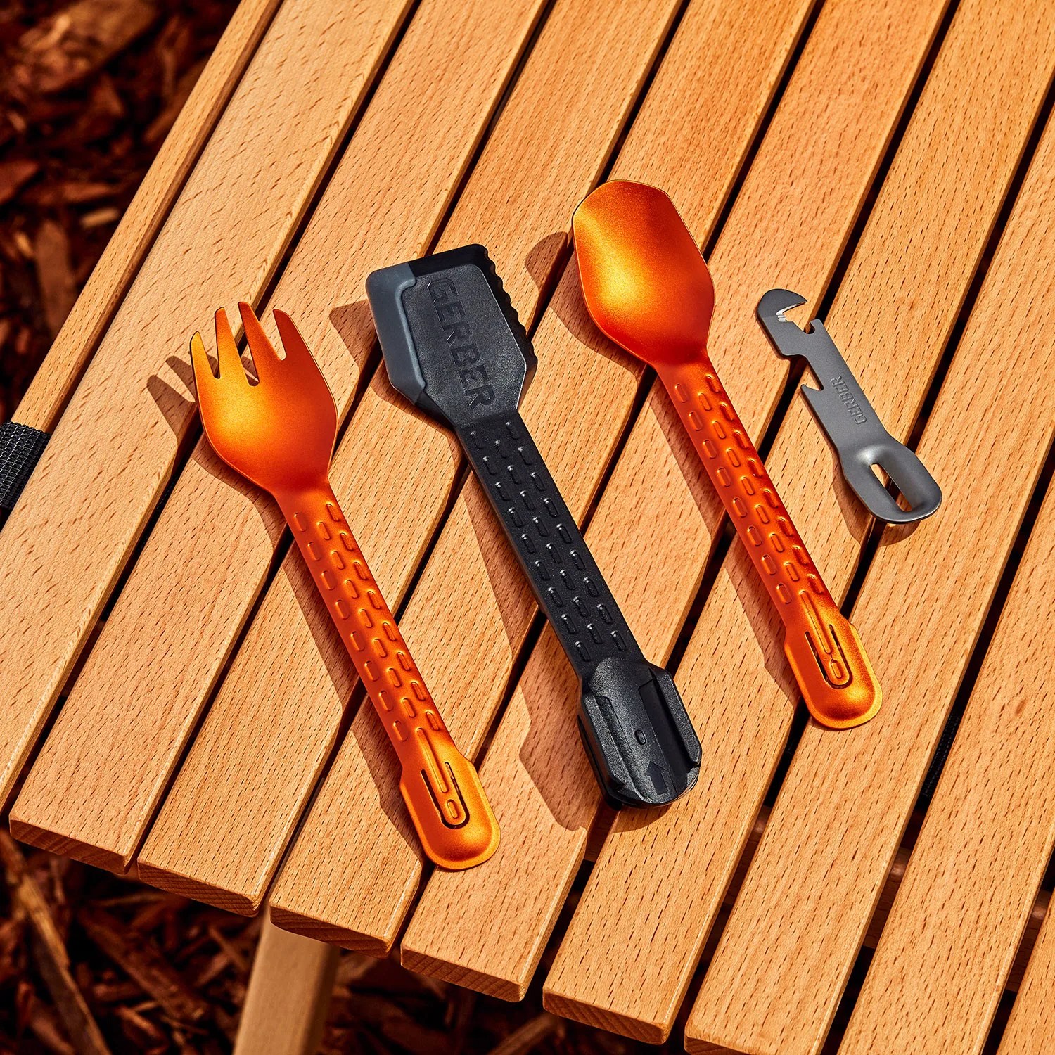 camp cooking utensils on slated wood surface