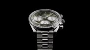 a diamond encrusted omega speedmaster watch against a black background