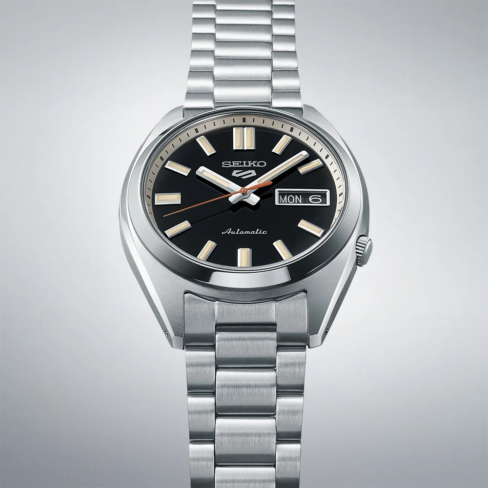 black seiko watch viewed against a white and gray backdrop
