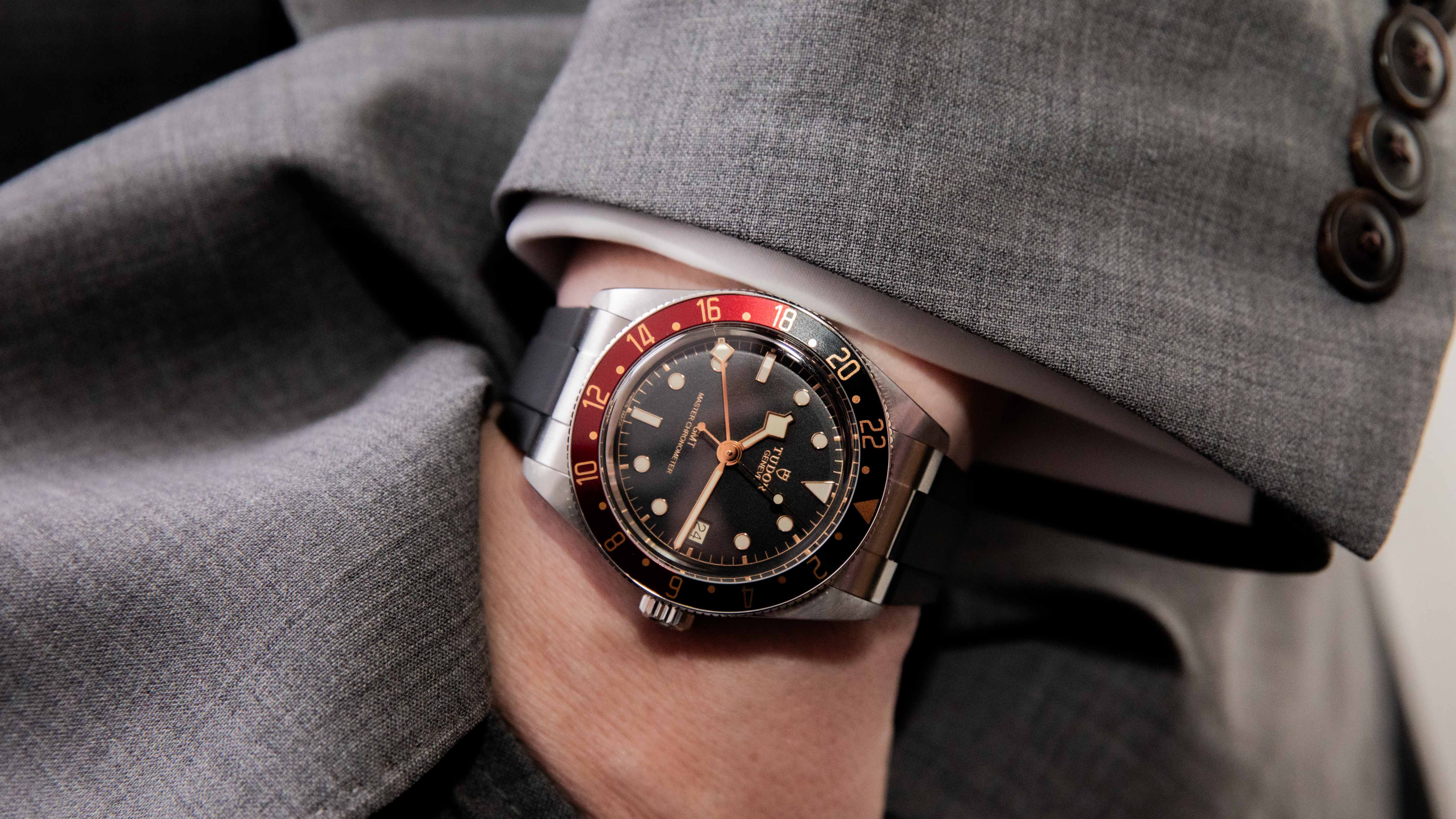 tudor watch on the wrist of a man wearing a suit