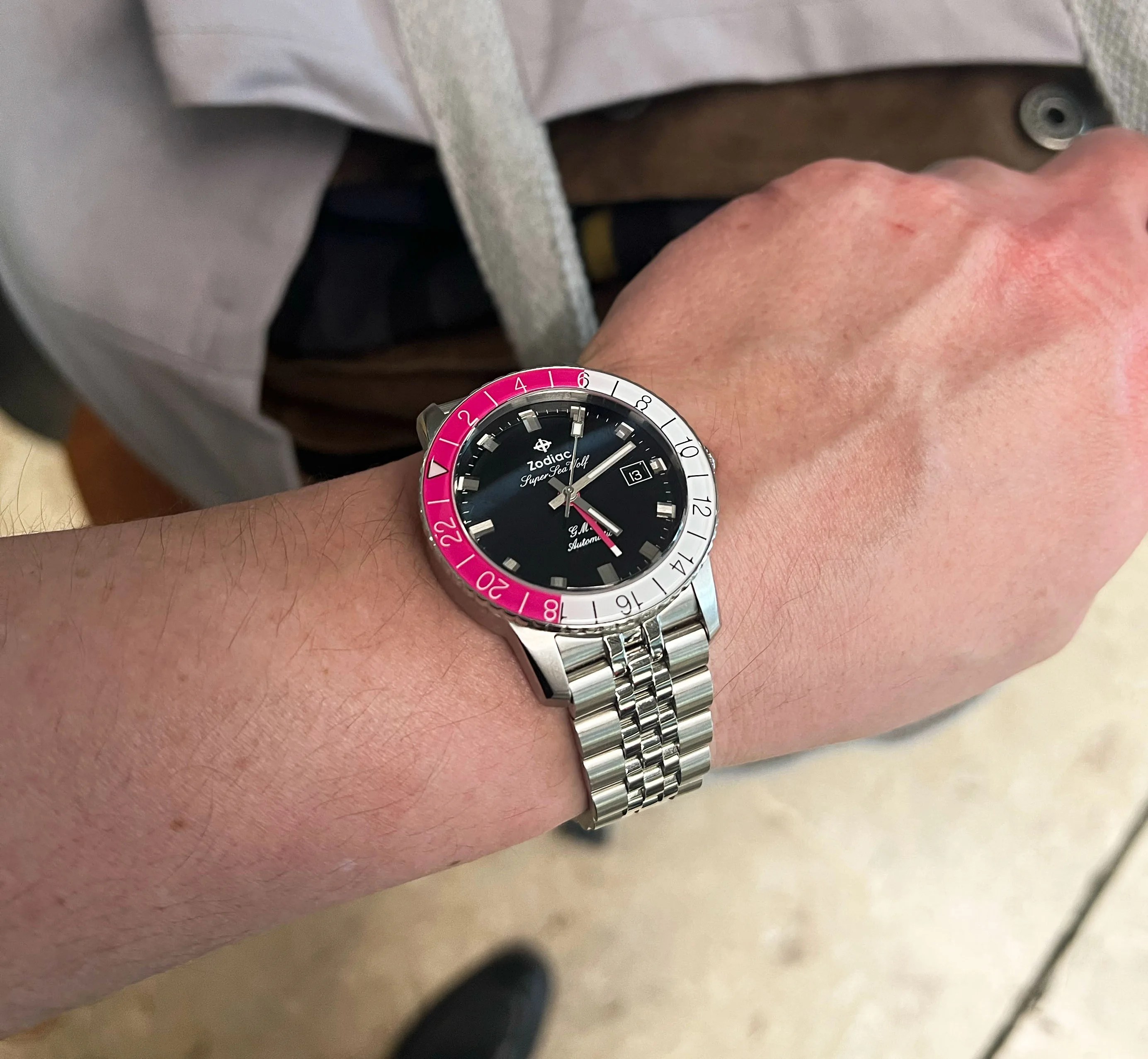 pink zodiac watch on mans wrist
