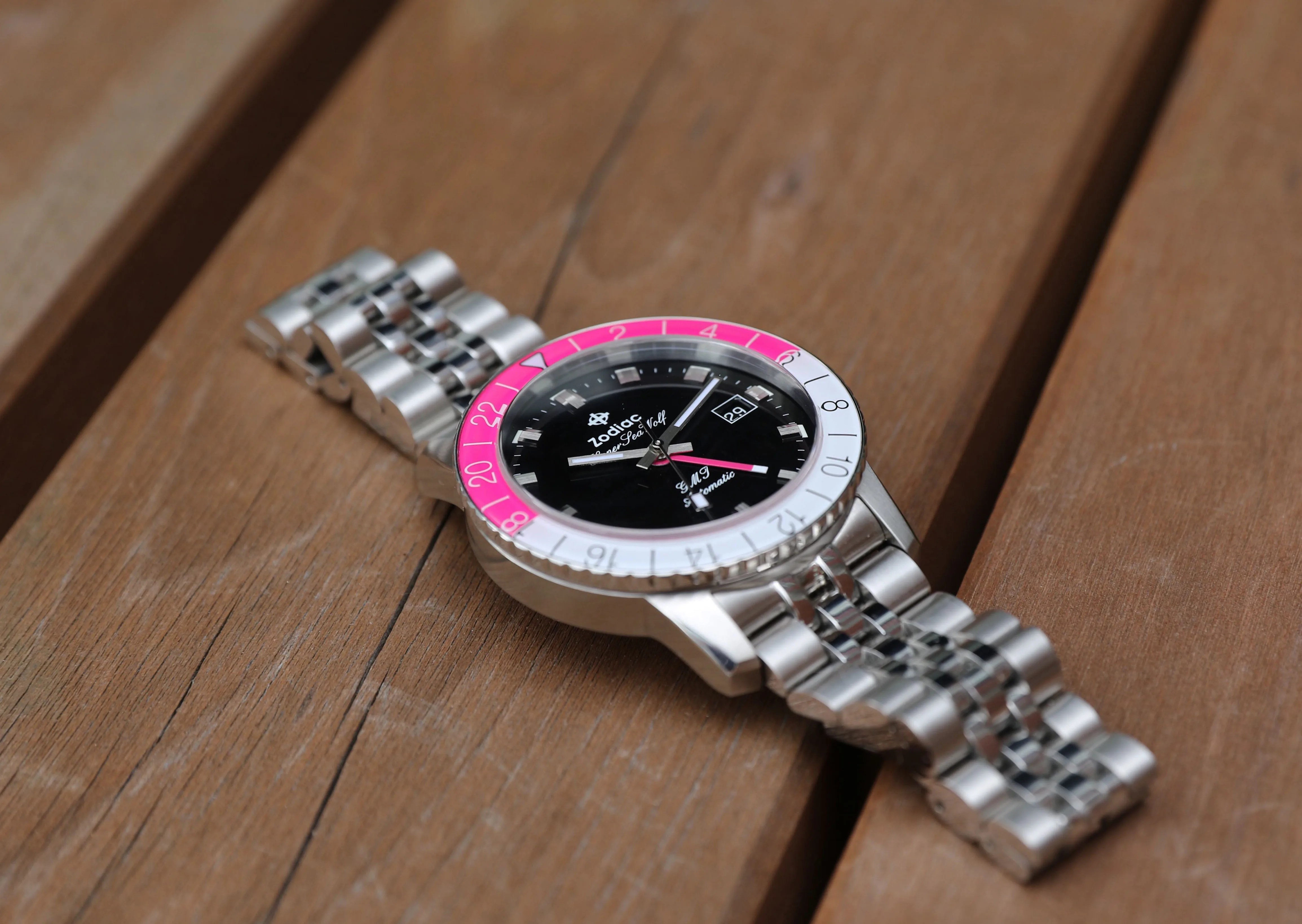 pink zodiac watch on a wood table