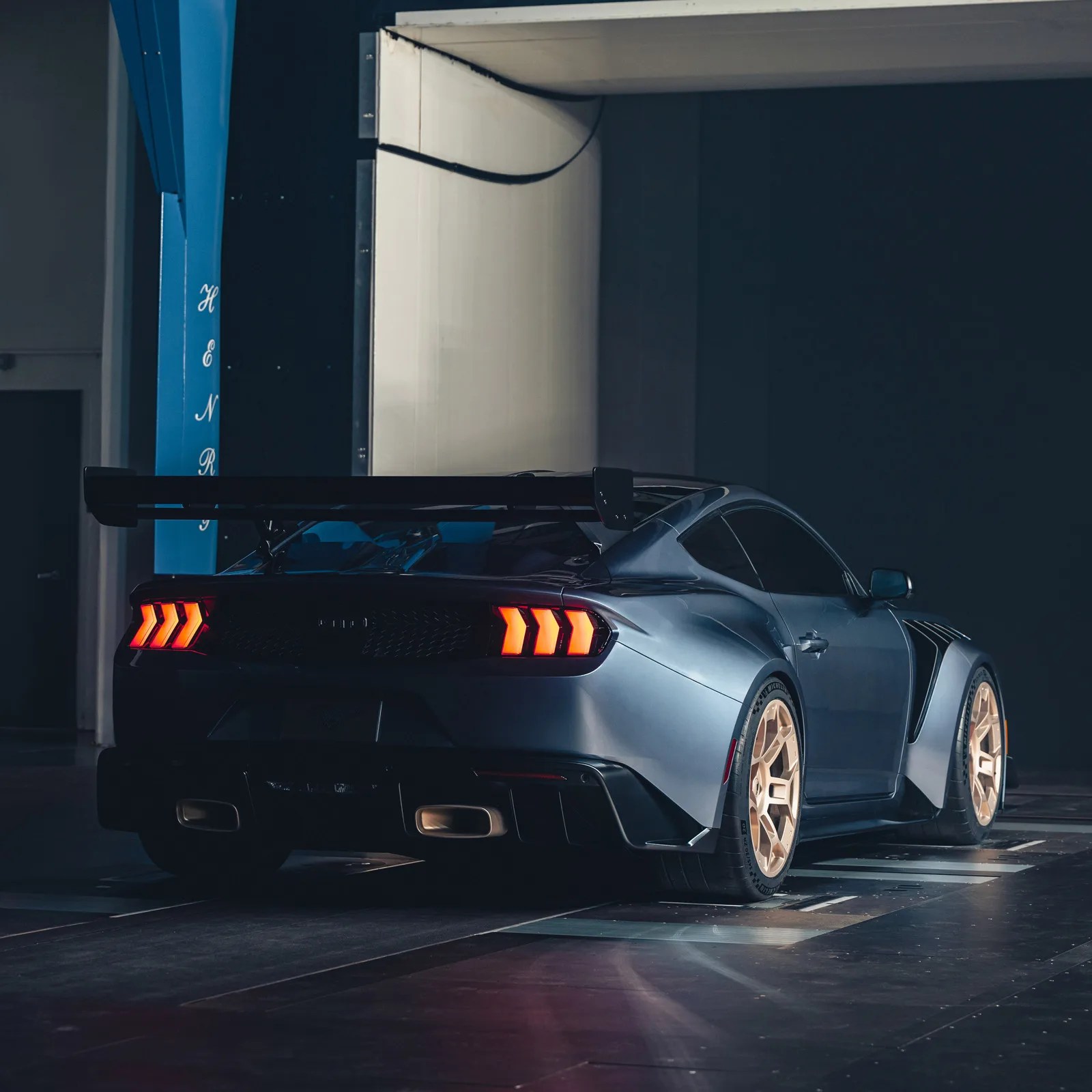 Ford Mustang GTD photographed from behind with tail lights on waiting sitting in a wind tunnel