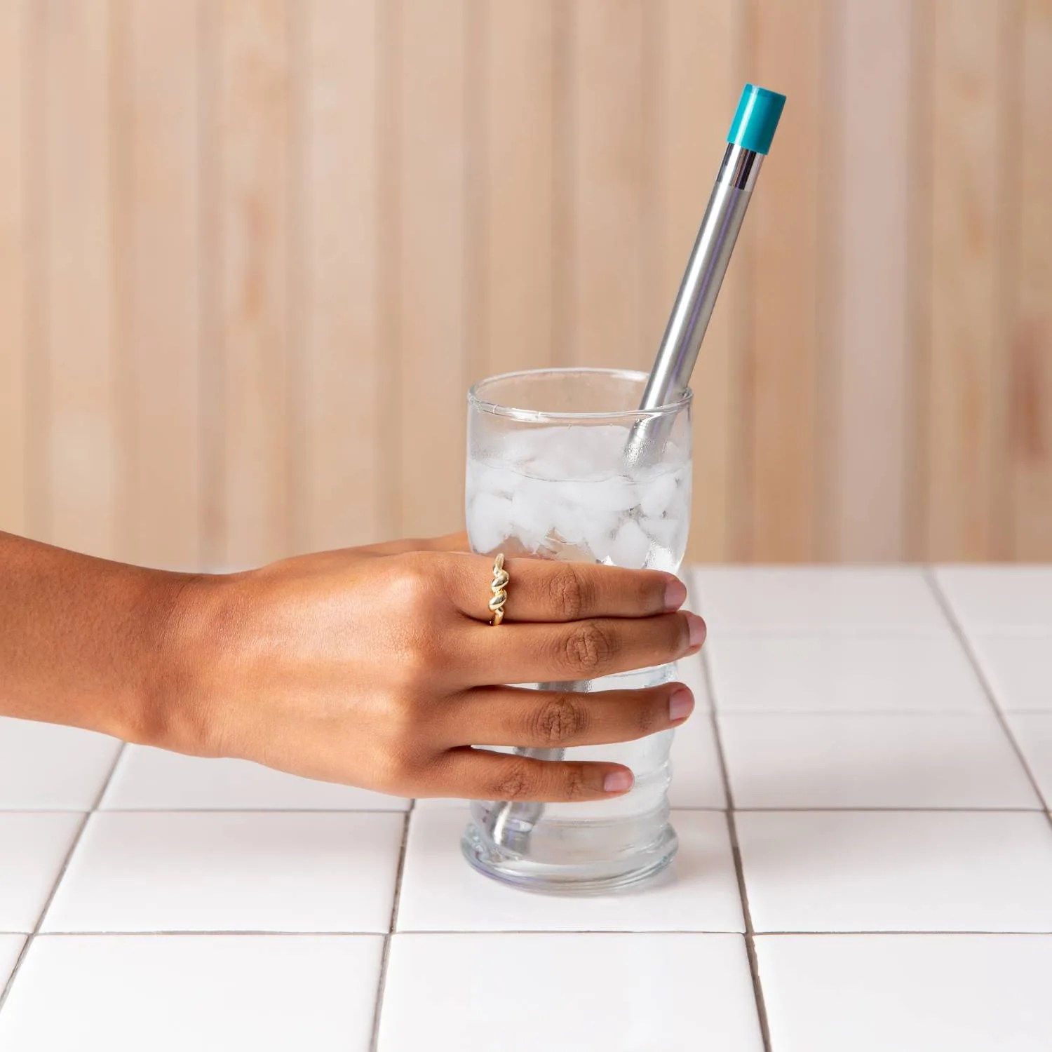 LifeStraw Sip in drinking glass being held in hand. 
