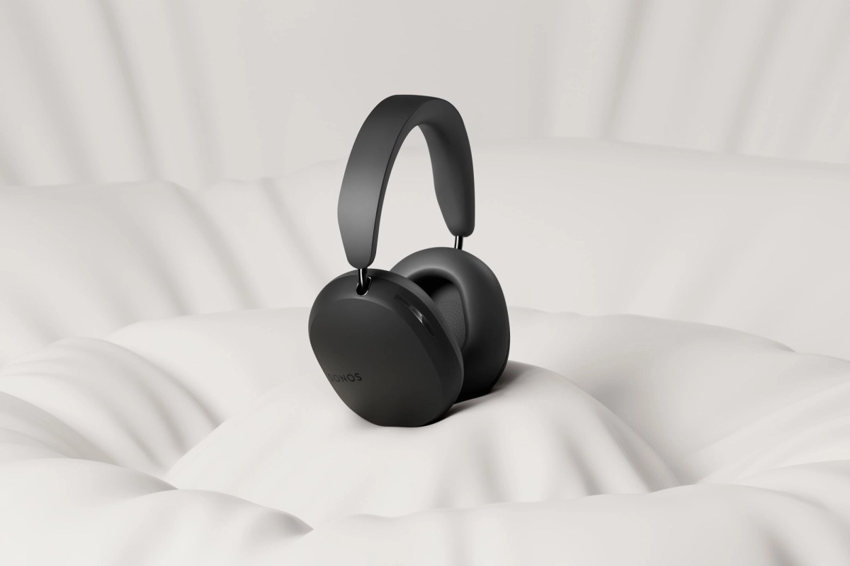 A pair of black sonos ace headphones sitting in an empty white room