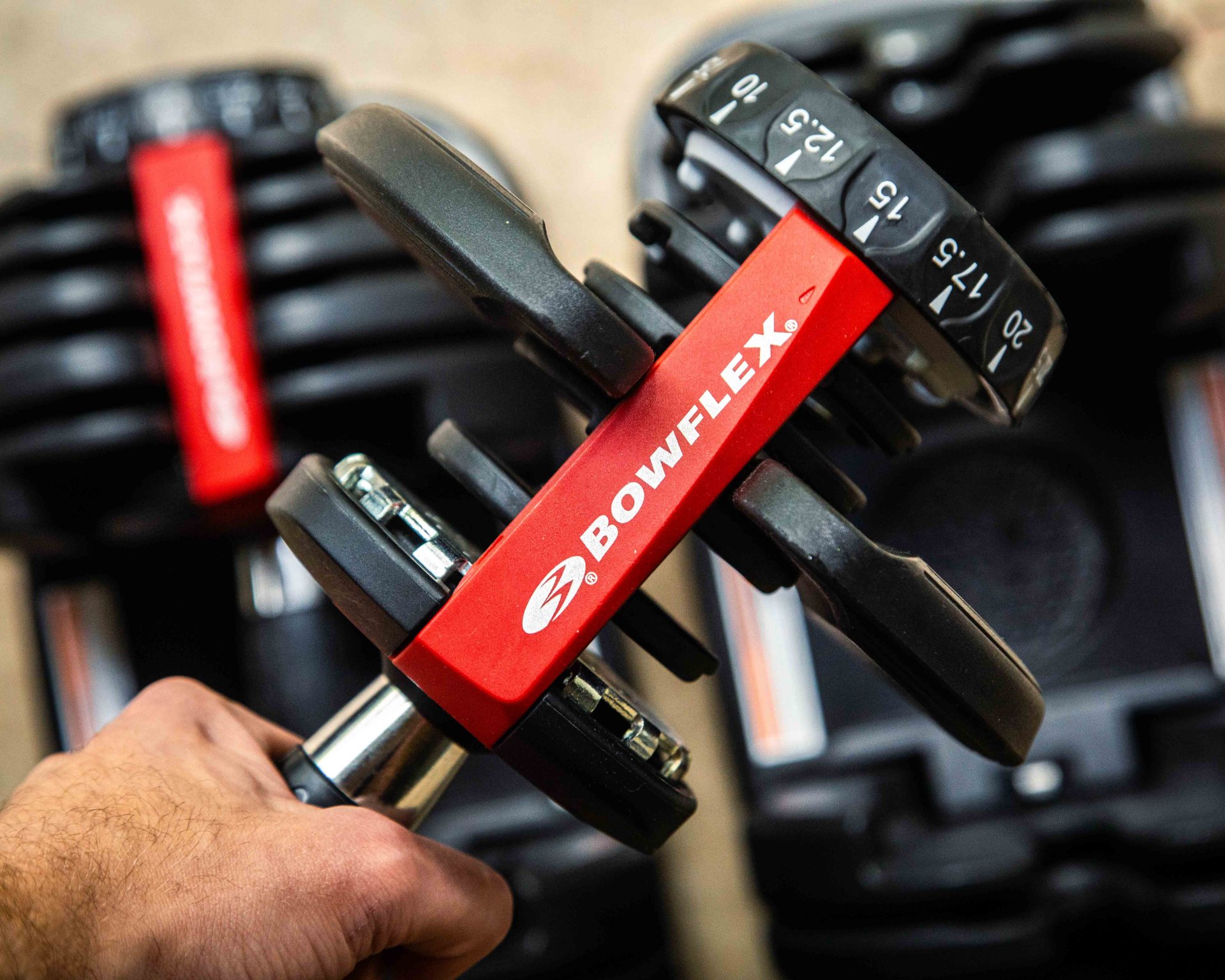 man holding a bowflex adjustable dumbbell