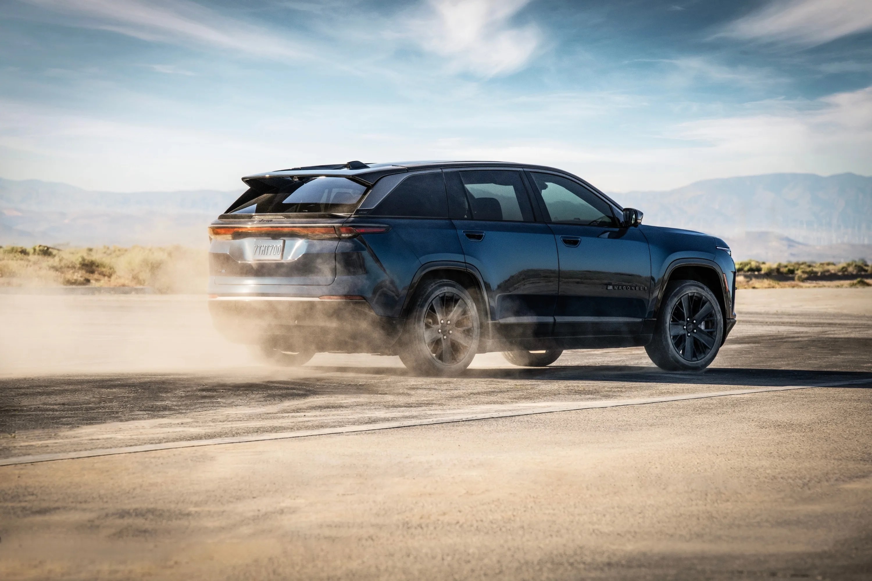 a jeep suv kicks up a dust cloud