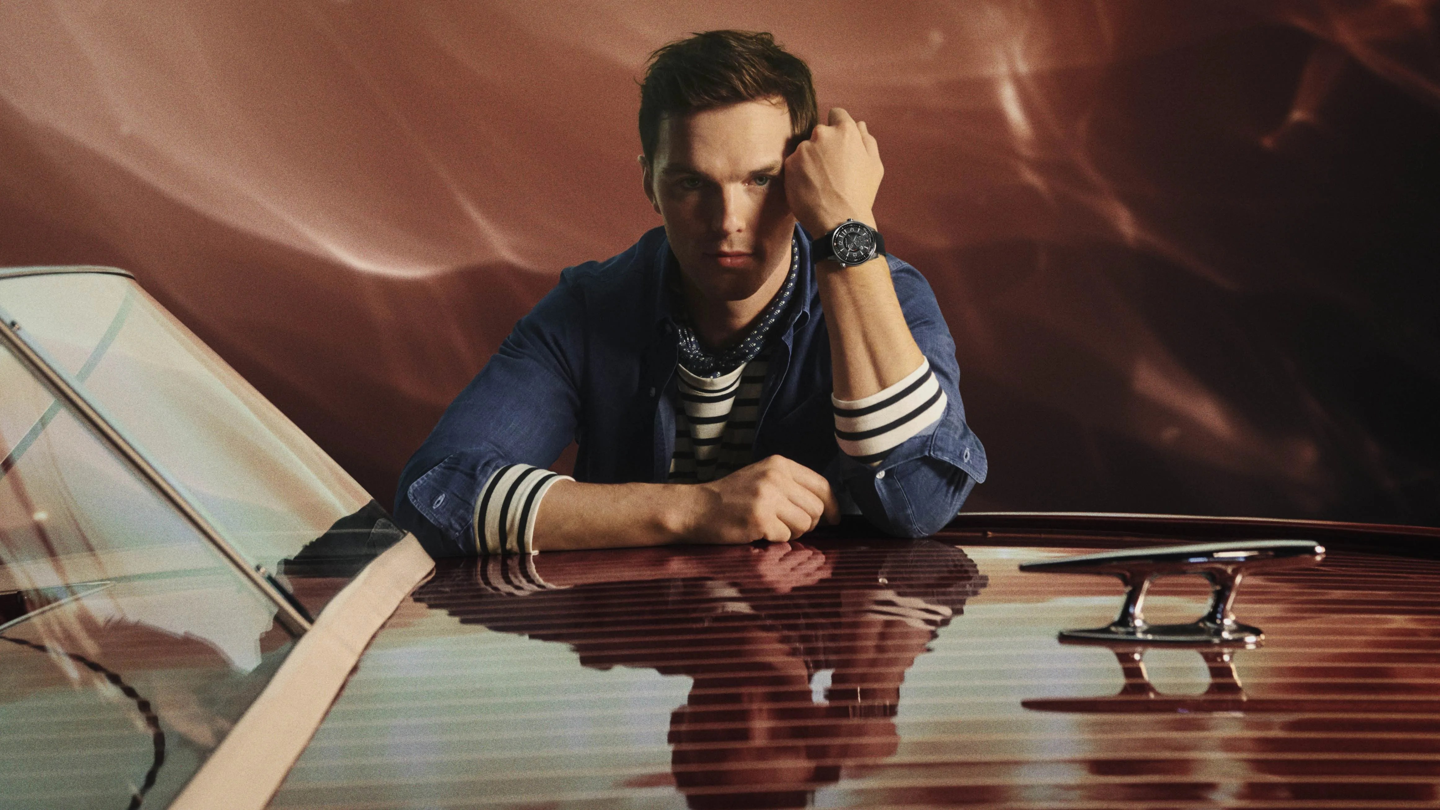 actor Nicholas Hoult poses on a boat wearing a jlc watch