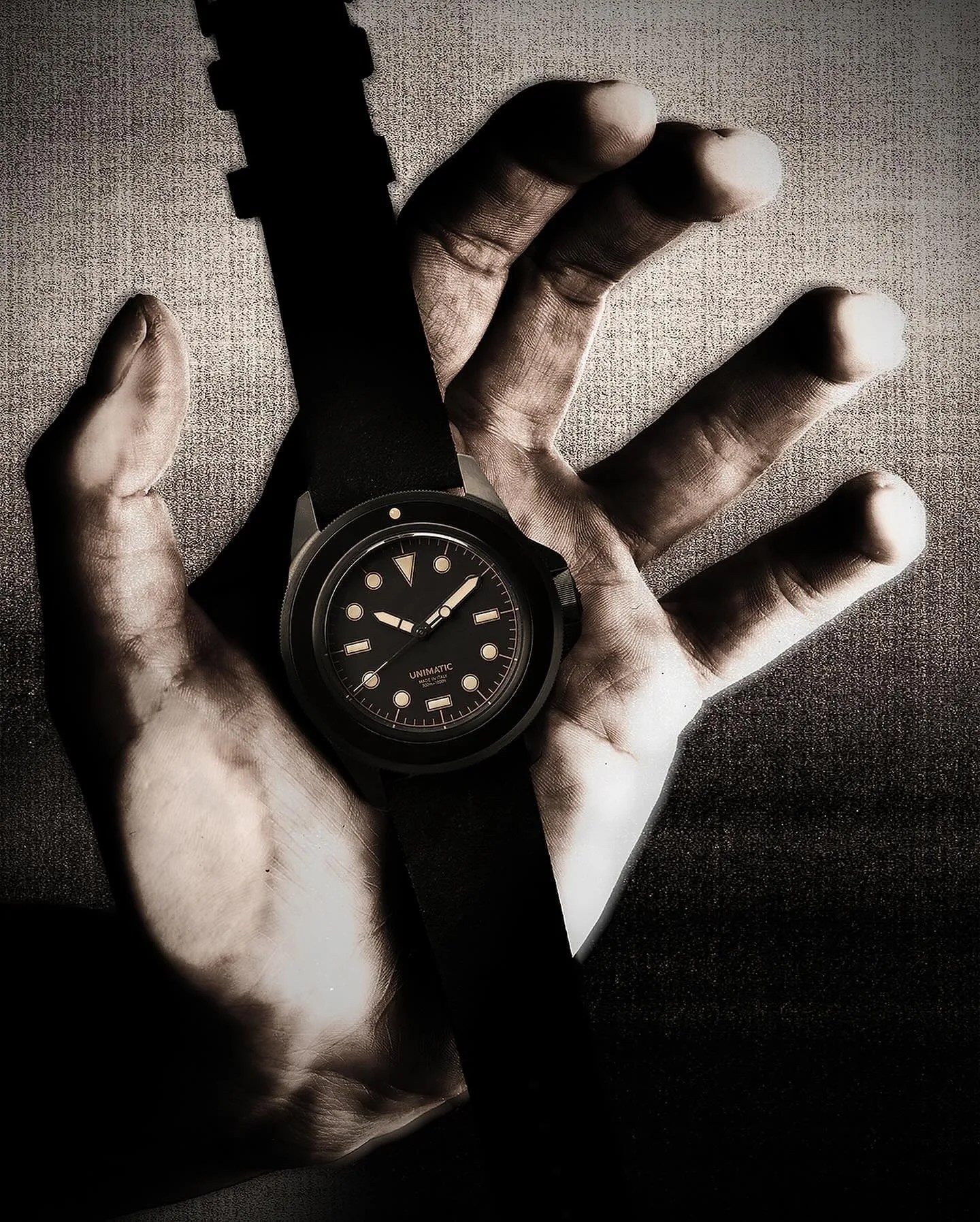 black unimatic watch in a persons hand