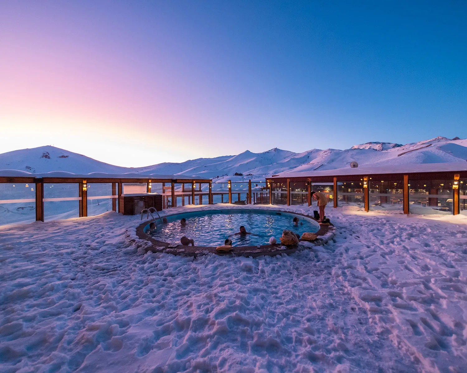 jacuzzi at sunset with snow mountains