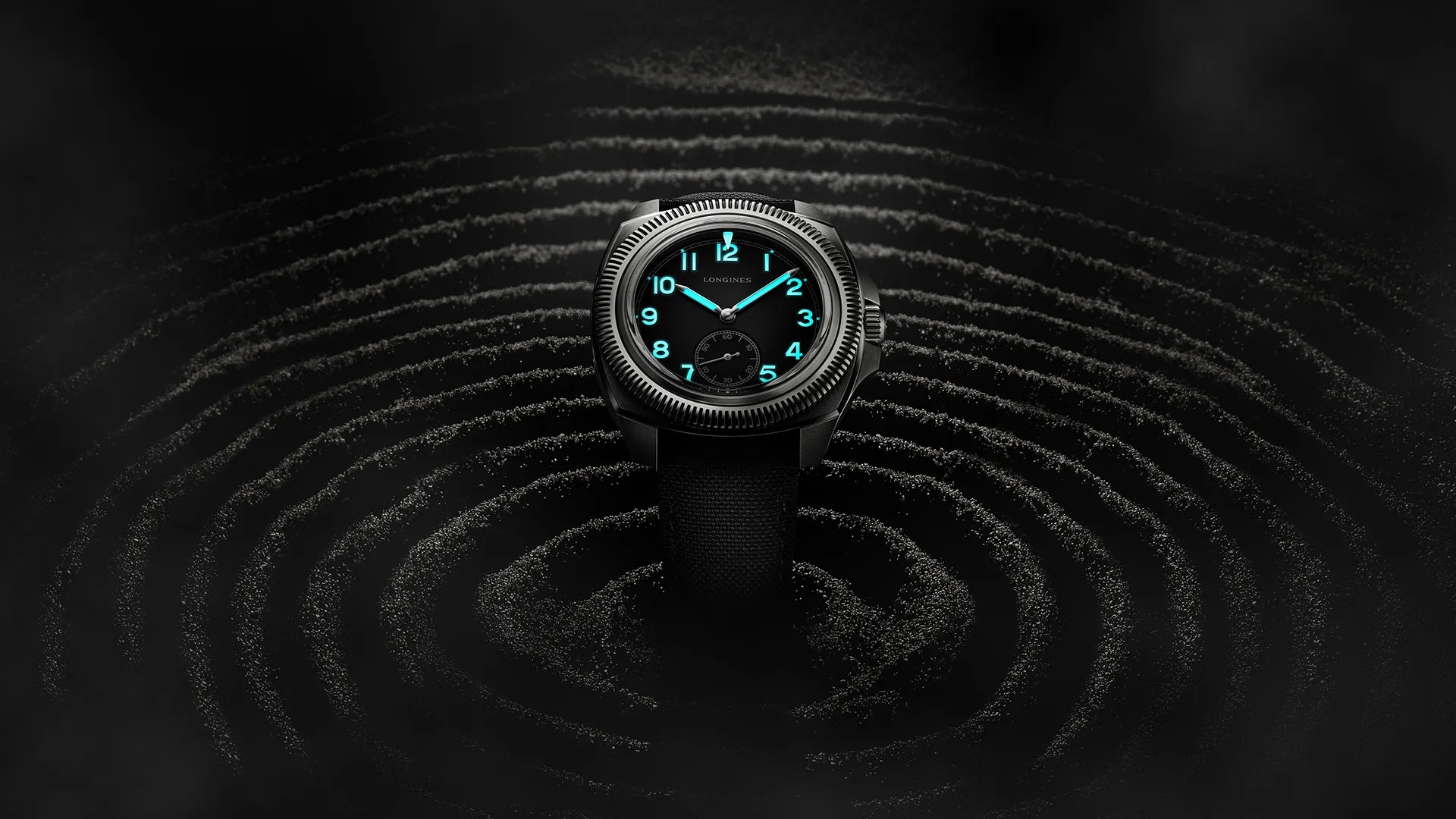 longines watch glowing in the dark over black sand