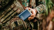Yeti navy flask being placed into a camouflage pouch