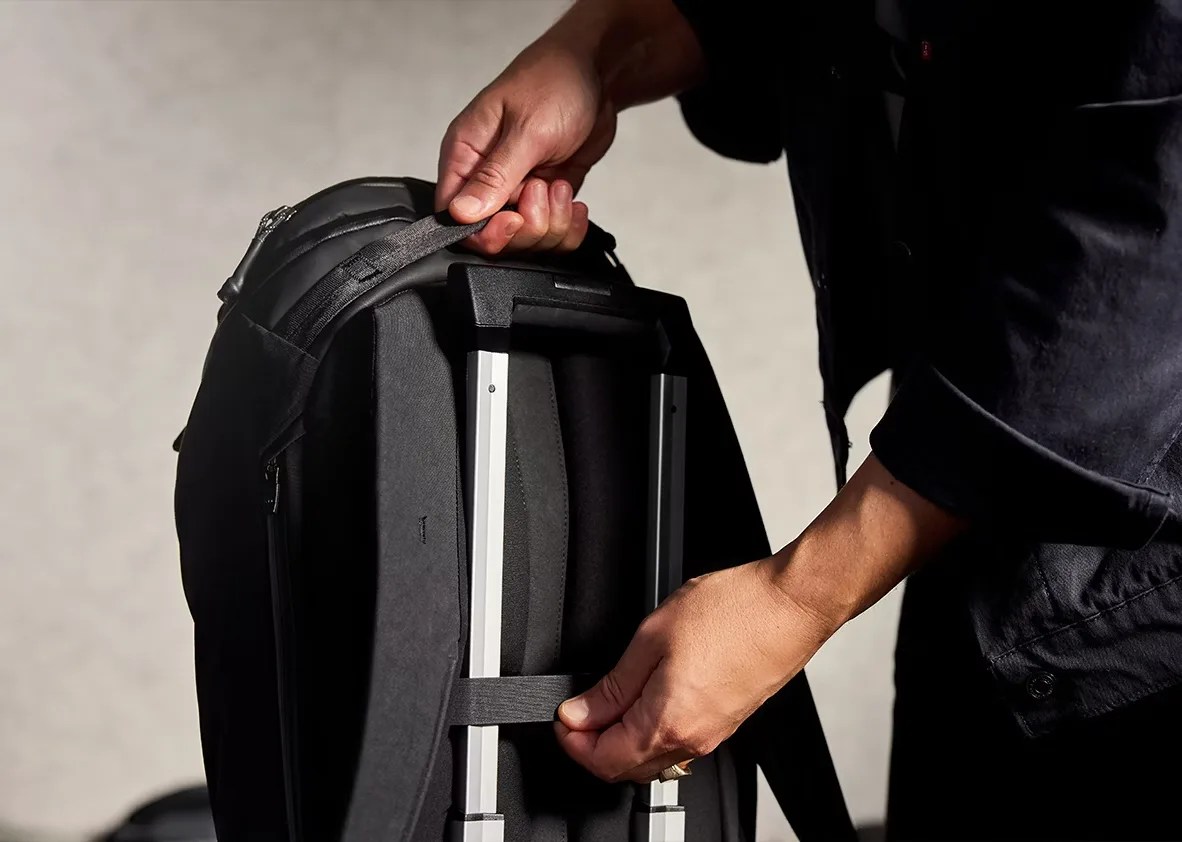 Bellroy backpack being slid onto a roller suitcase handle