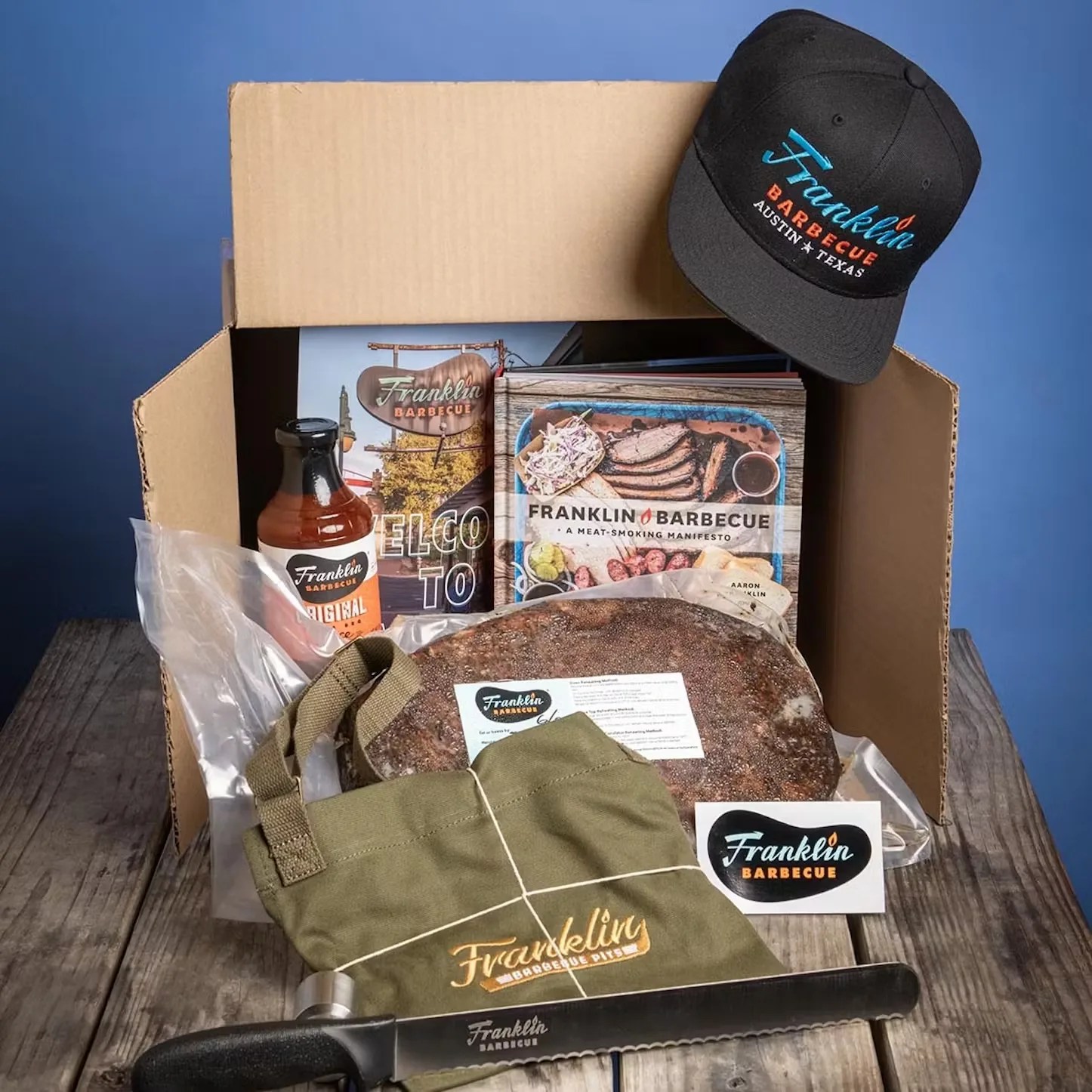 box containing franklin barbecue meats and merch