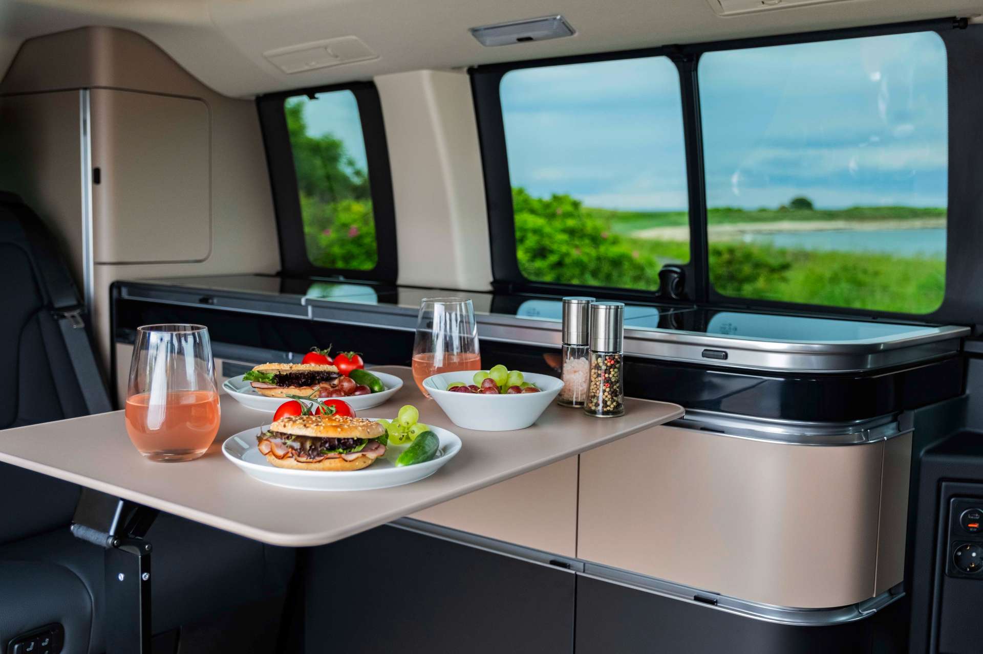 mercedes camper van interior showing a table with plates of food and drinks