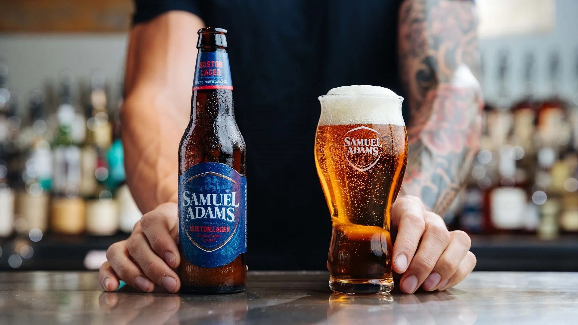 a bartender serves sam adams beer in a glass