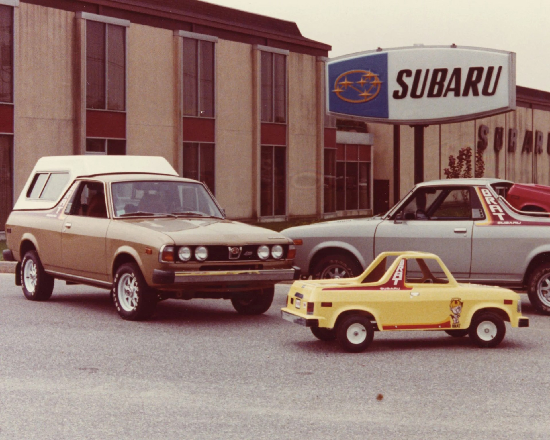 vintage photo of a subaru dealership with BRAT trucks in the parking lot