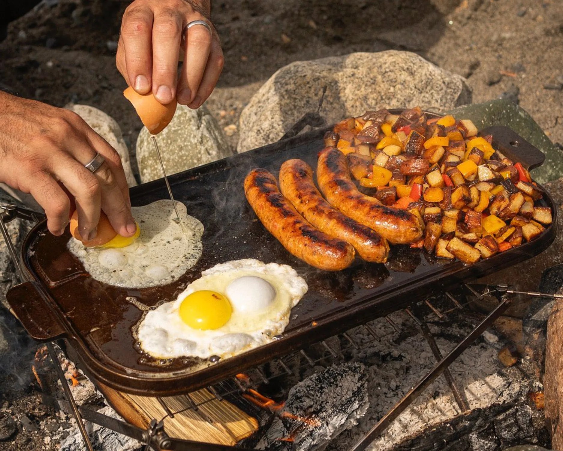 person cooking outdoors with a griddle