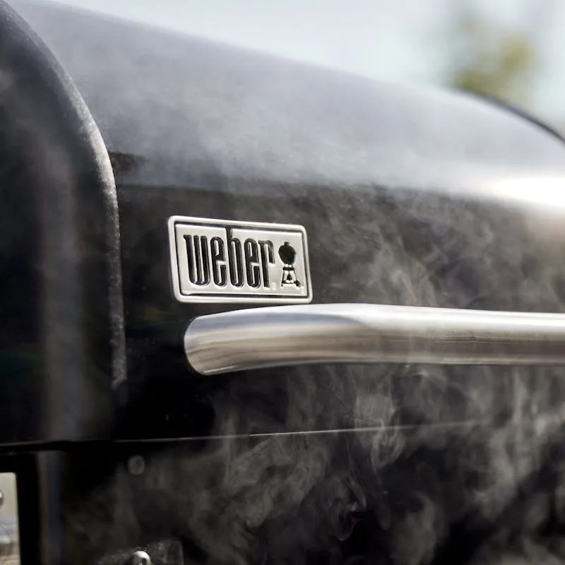 closed smoking weber grill with logo in metal