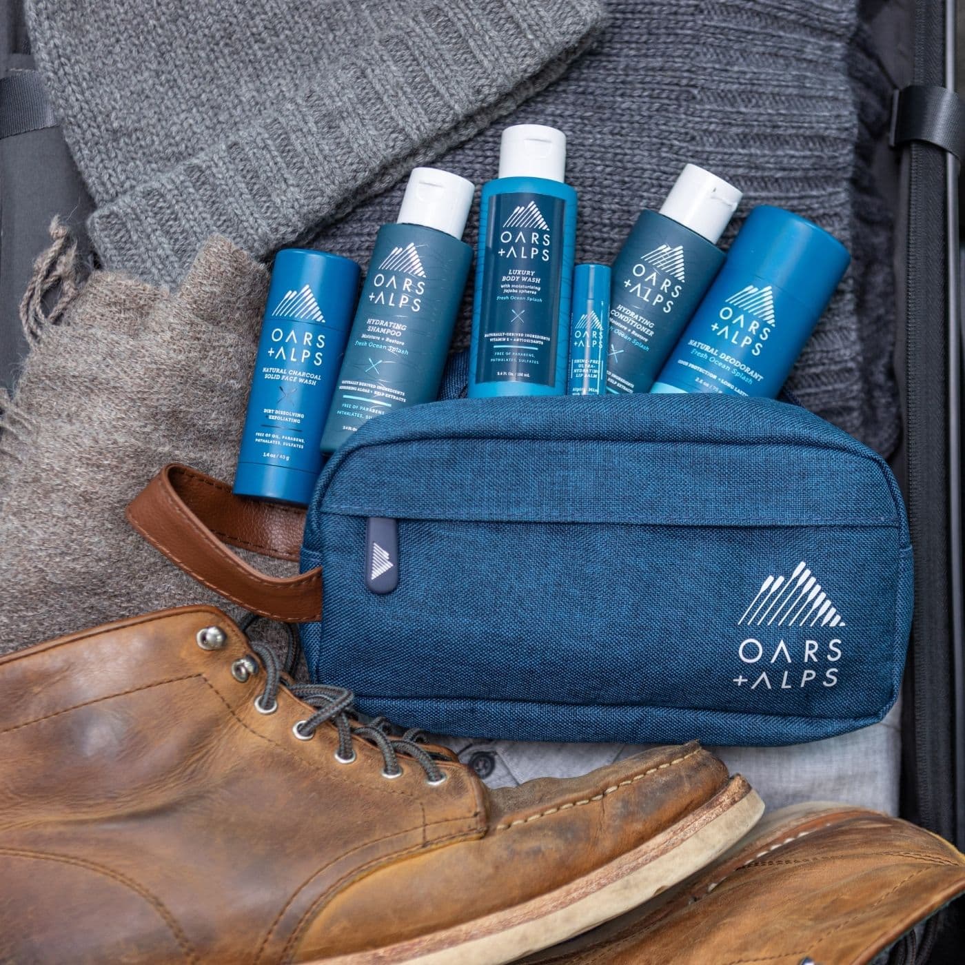 collection of oars + alps grooming products coming out of a blue dopp kit