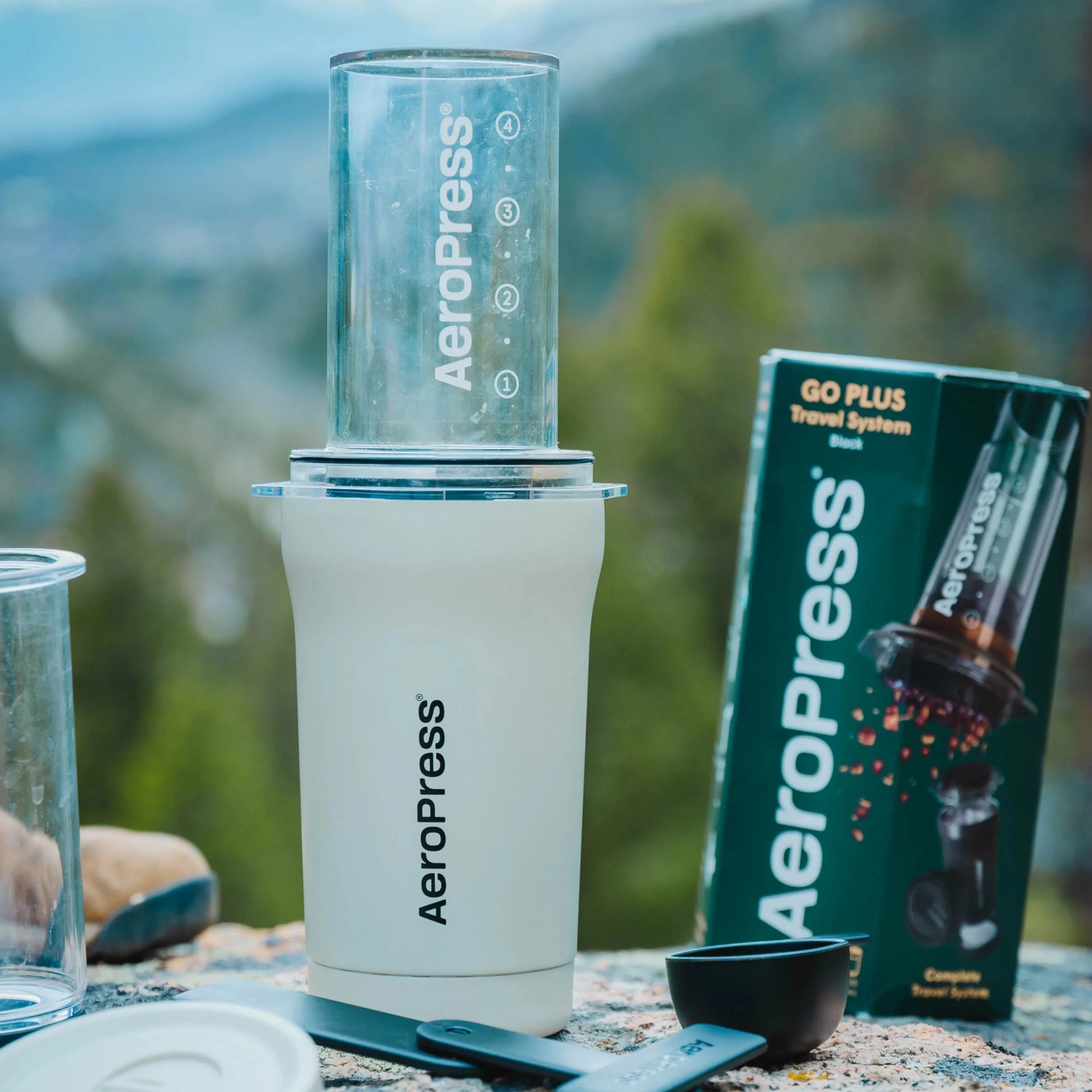aeropress go coffee maker on a rock with mountains in the background