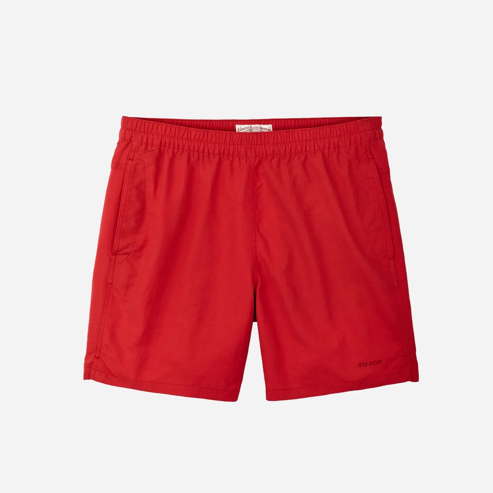 A pair of bright red Filson Cooper Lake swim trunks shown flat resting against a light grey background