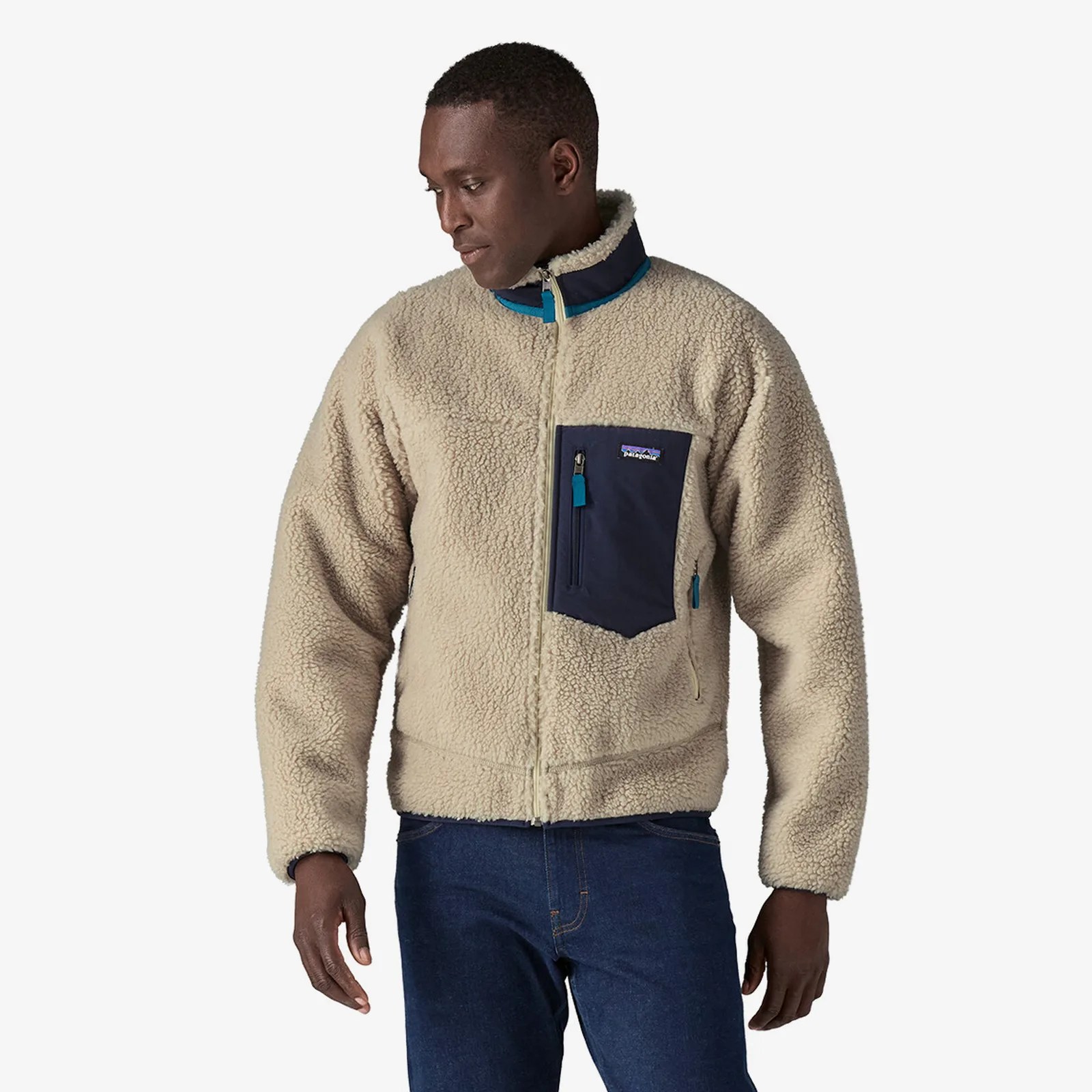 A black male wearing a Patagonia Retro-x fleece jacket in natural white