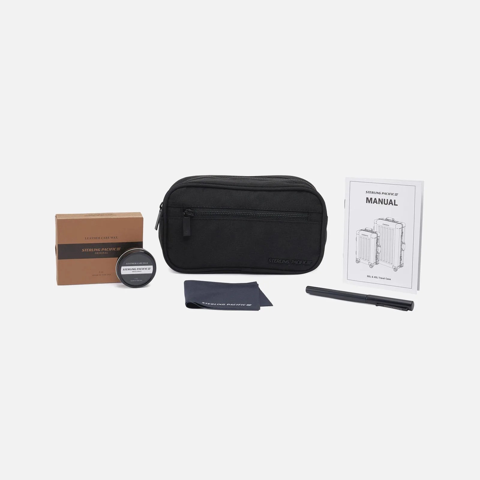 A line up of the accessories that come with a Sterling Pacific Cabin Travel Case including leather polish, a small electronics pouch, a microfiber cloth and a metal pen. 