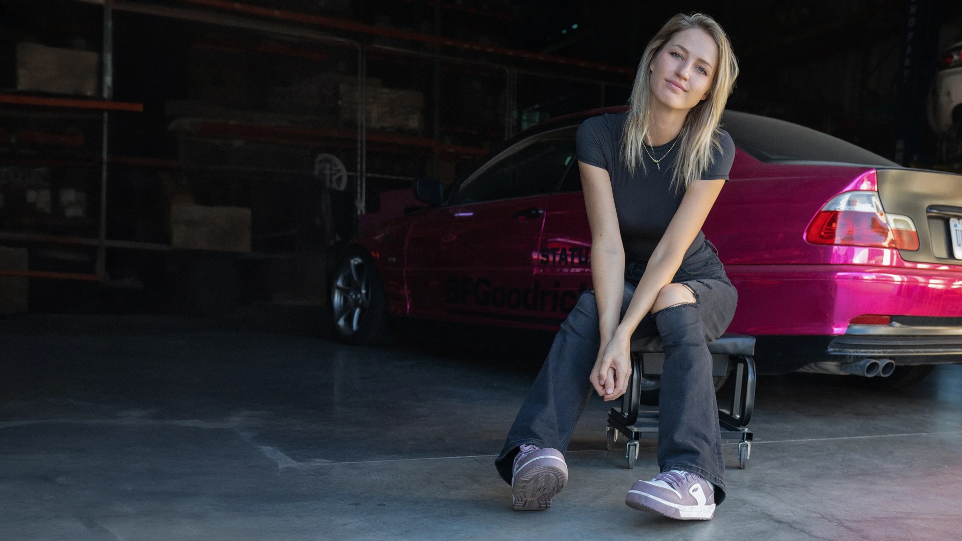 Gabby Downing sits in front of her pink BMW