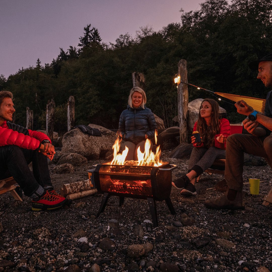 group of people gathered around a biolite firepit in the mountains