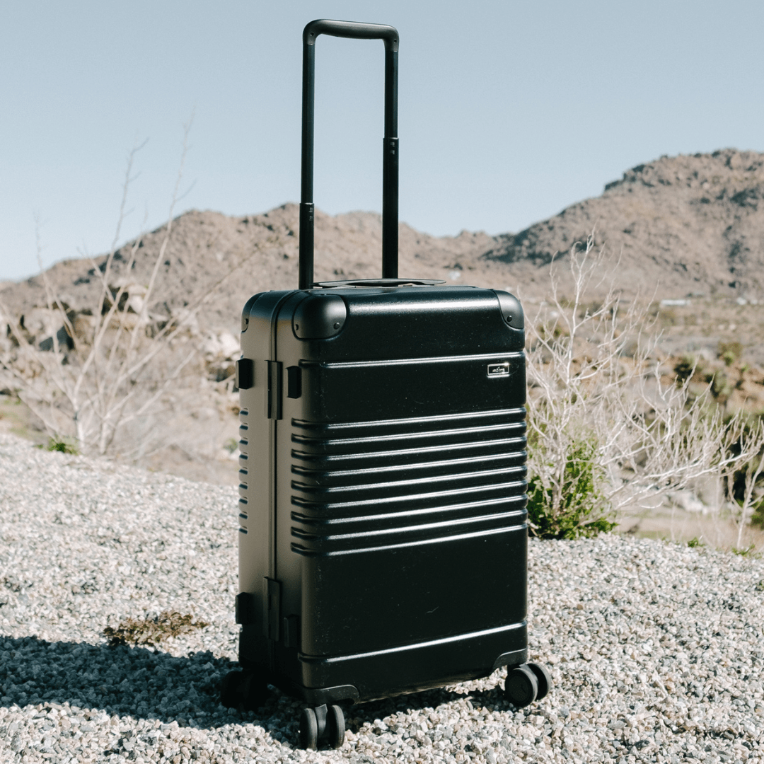 black arlo skye suitcase in a desert
