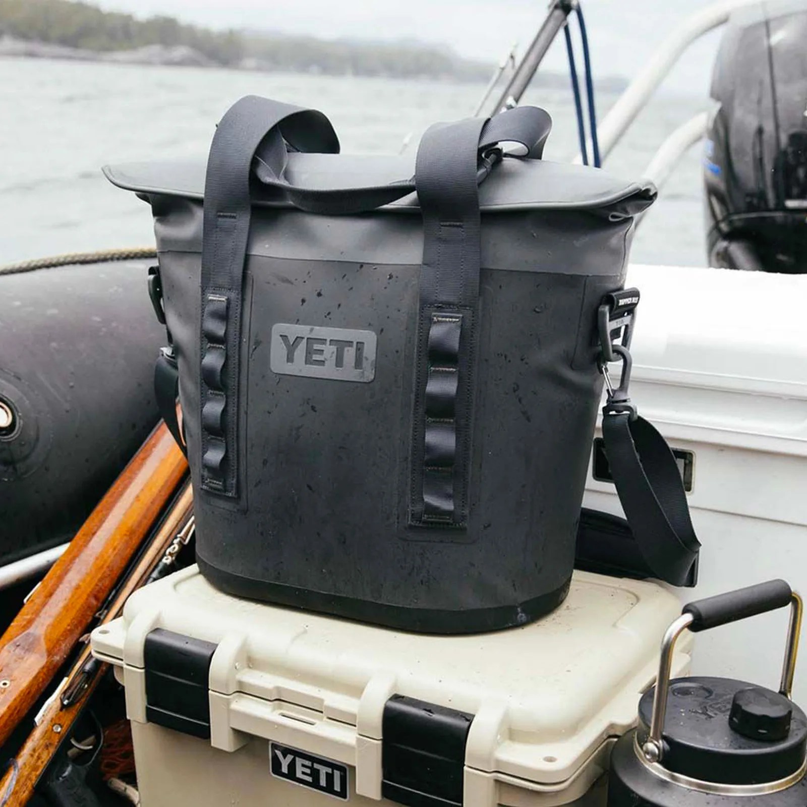 Yeti m15 soft cooler in grey sitting on another Yeti cooler in a rubber boat on the water