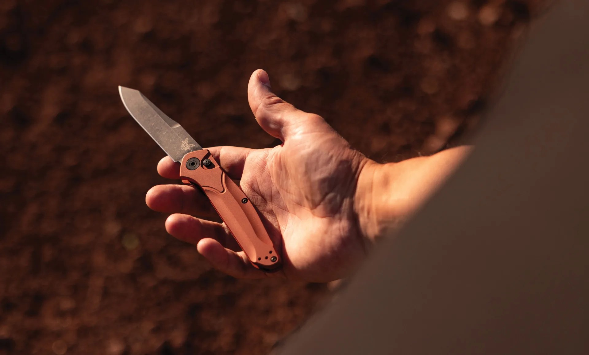 mans hand holds a benchmade pocket knife
