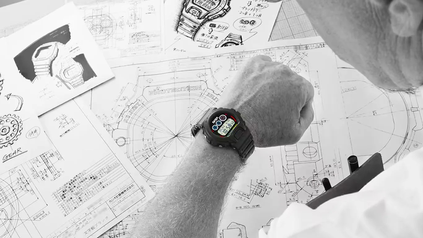 a black and white photo of a scientist looking at his g-shock watch