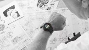 a black and white photo of a scientist looking at his g-shock watch