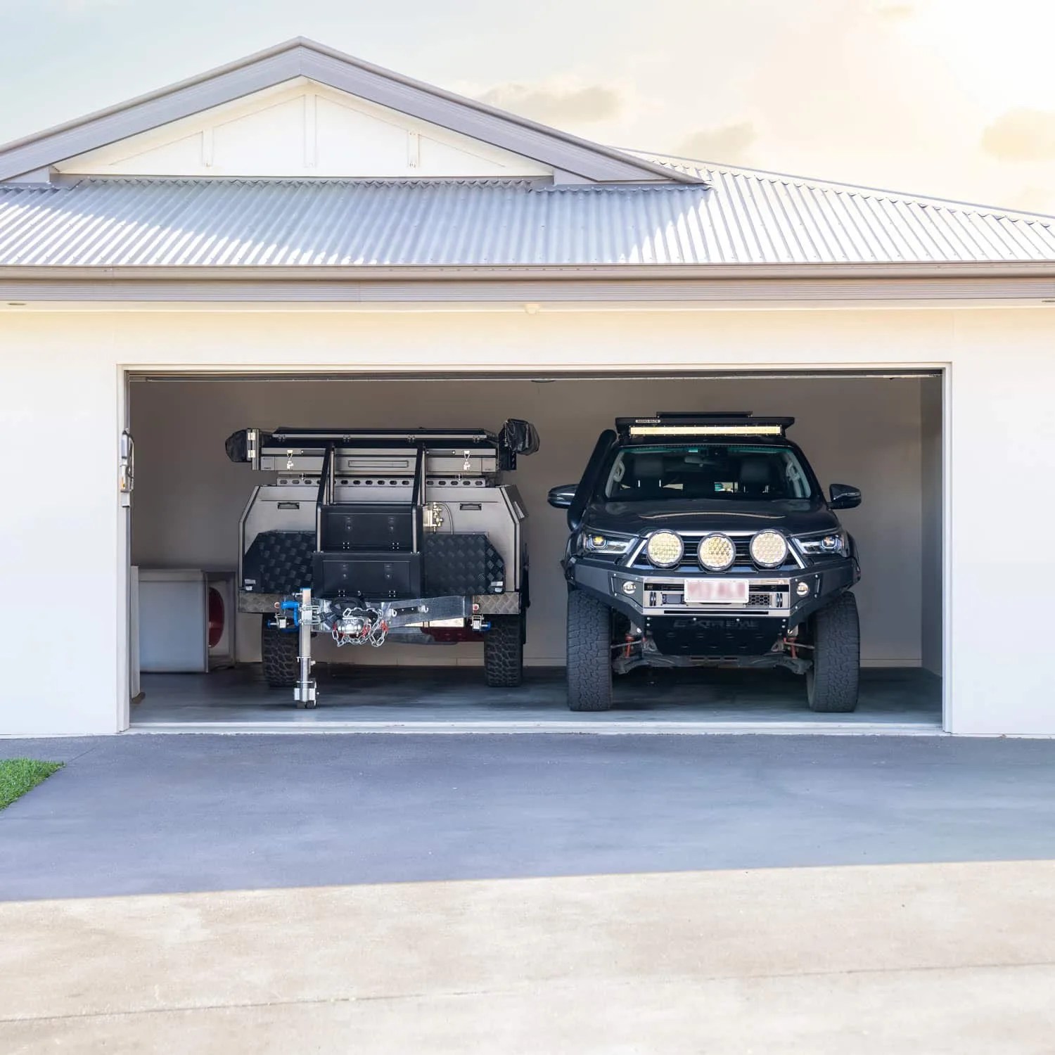 hardkore campers trailer next to a truck inside a garage