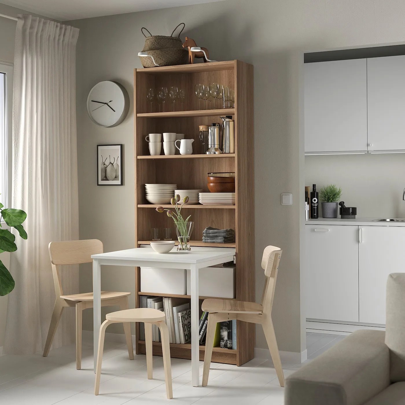 a compact dining room filled with ikea furniture including a table attached to a bookcase
