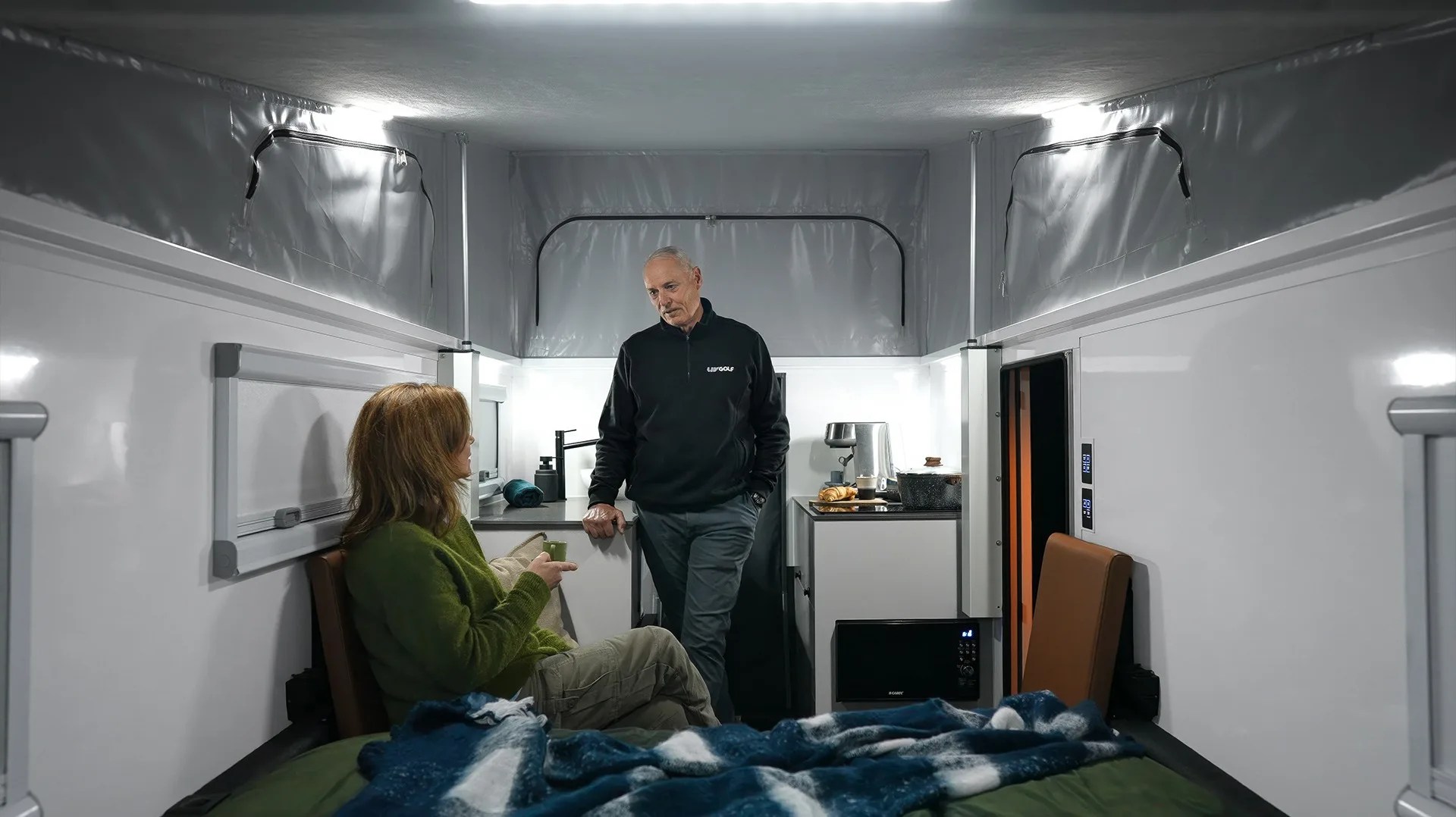 a man and woman hang out inside an offline campers camper