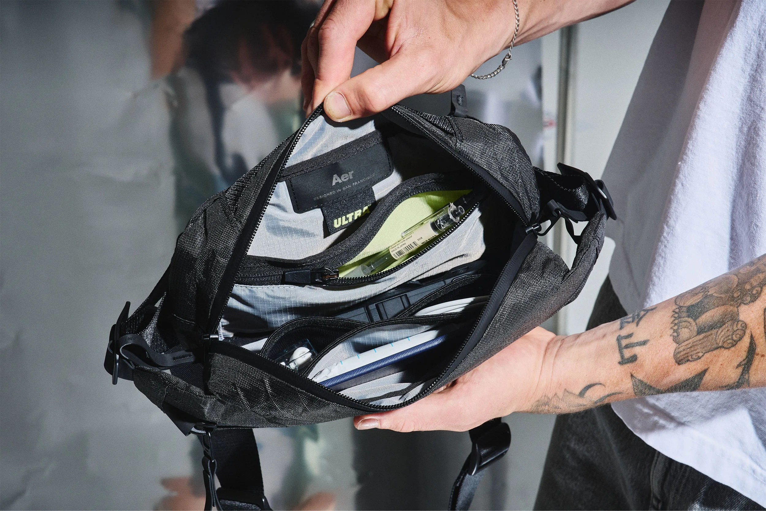 a man shows the interior of an aer sling bag