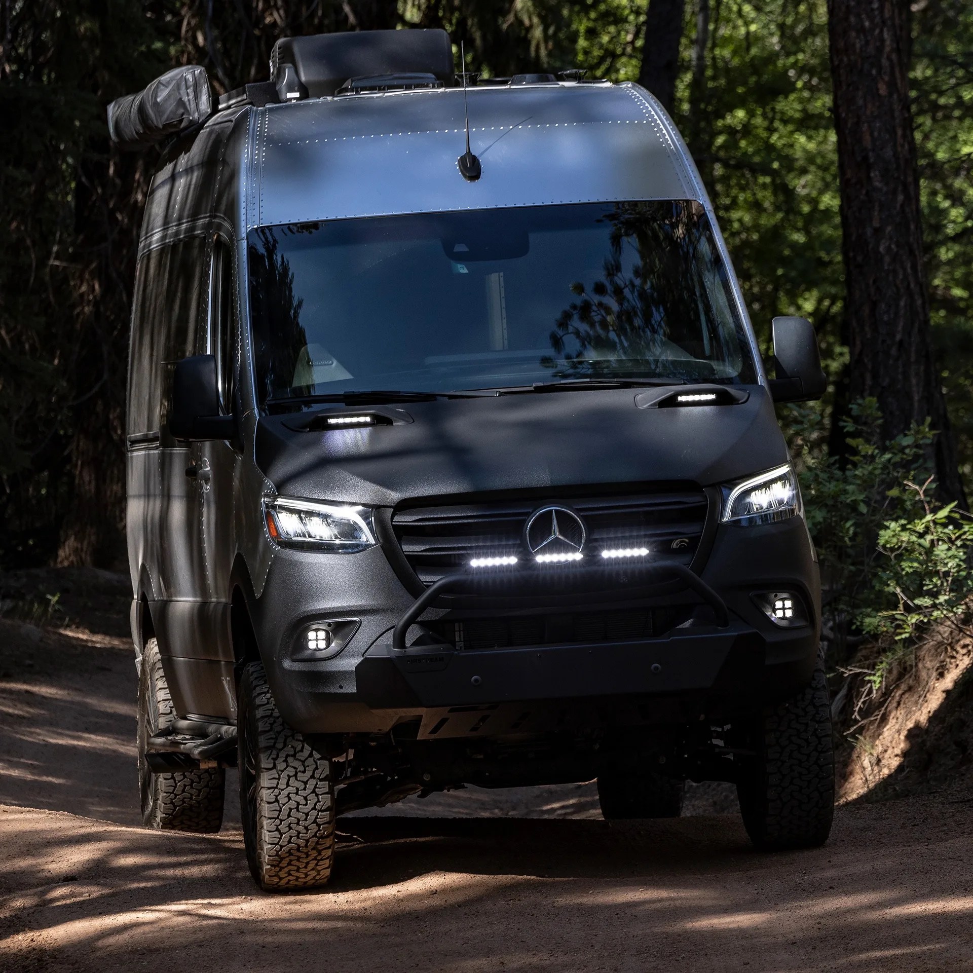 airstream camper van driving down a trail